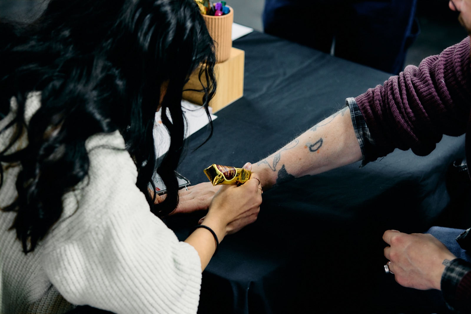 Preet applying henna to a guest's arm